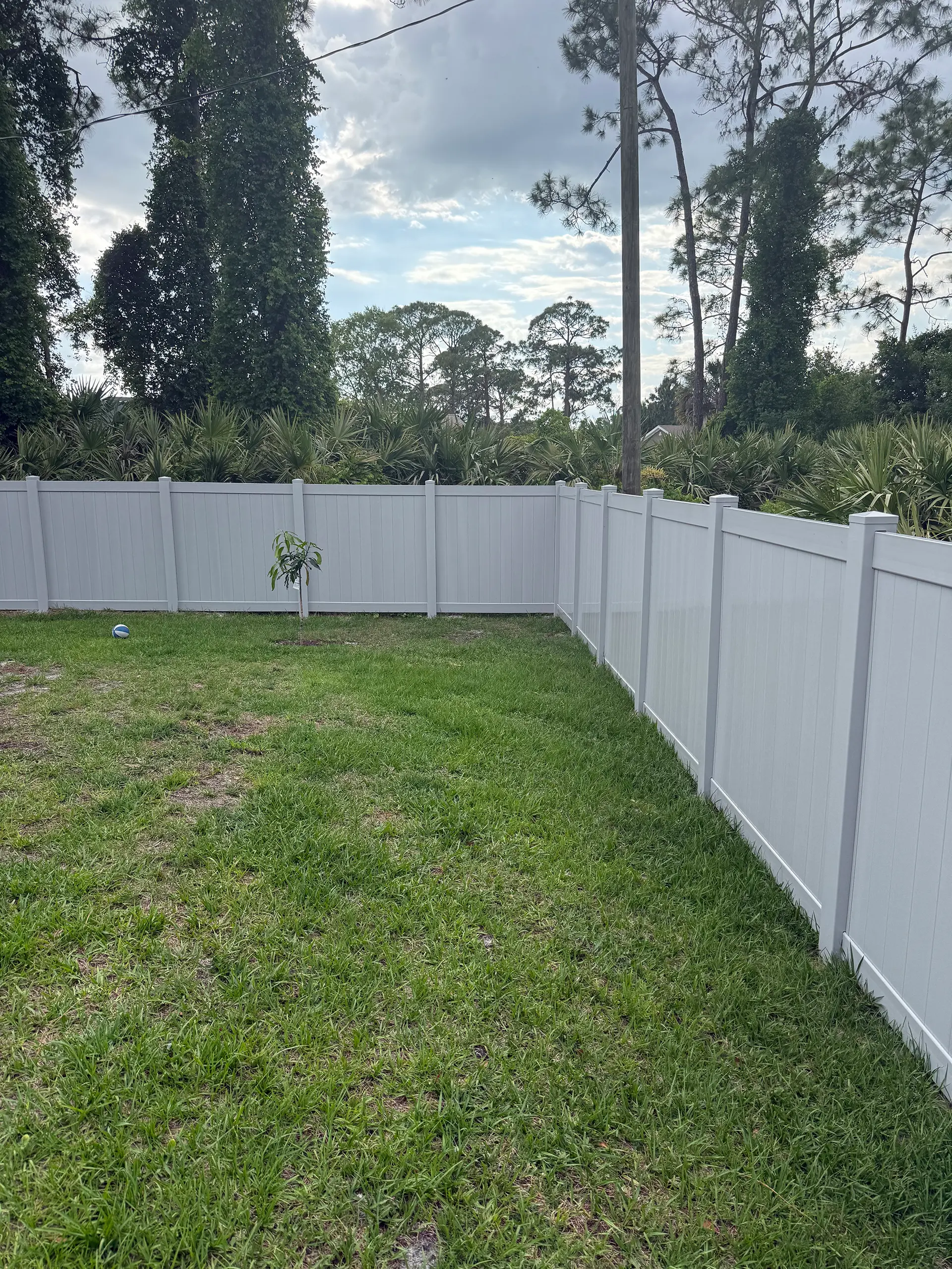 White vinyl privacy fence wrapping a residential backyard in East Central Florida